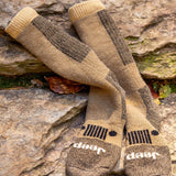 Pair of brown and beige socks with Jeep logo on a stone surface