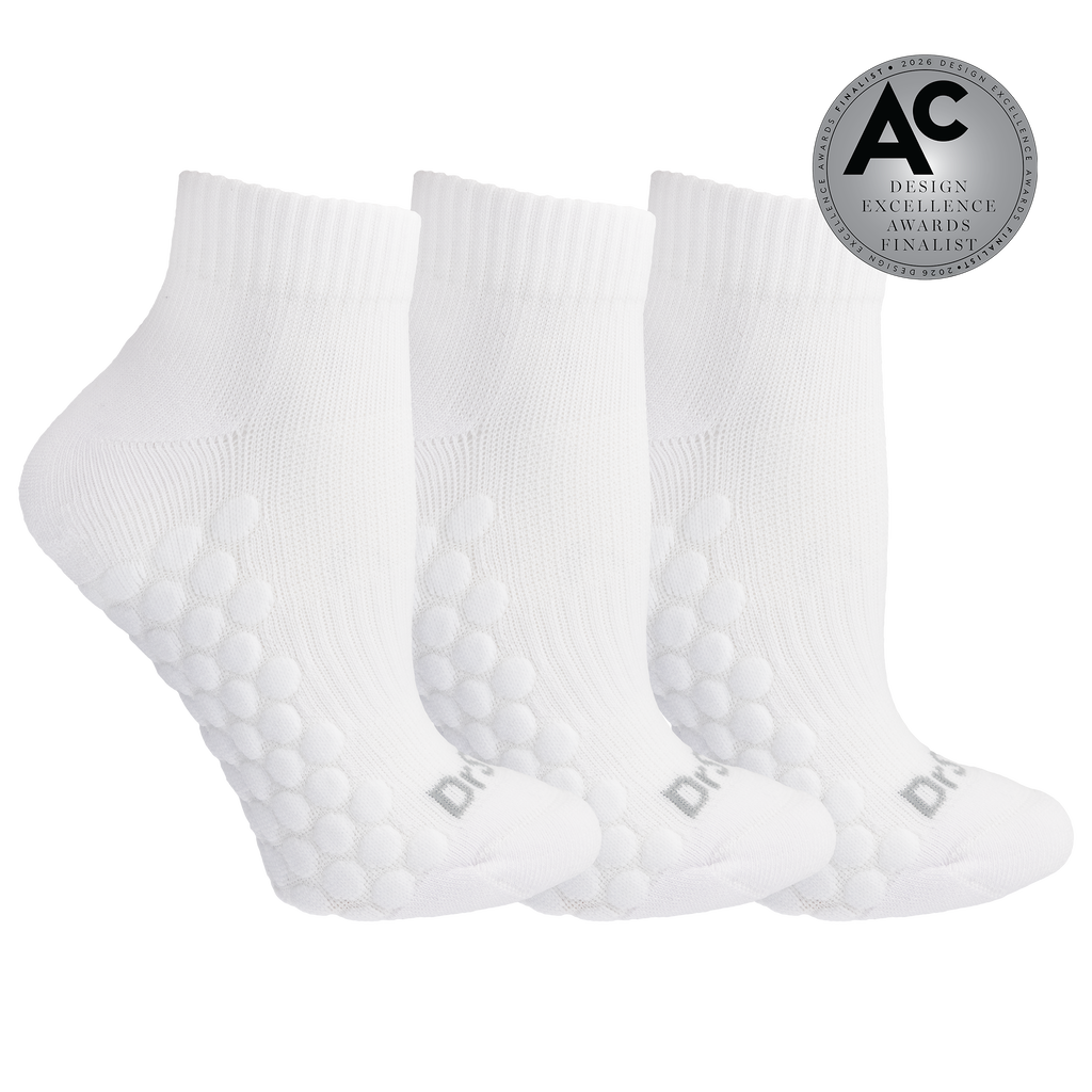 Three white ankle socks with raised bubble grip panels on the sole, shown on a white background with a silver award badge in the top right.