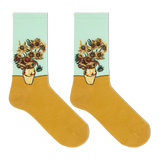 A pair of crew socks featuring a classic Van Gogh-inspired sunflower and chrysanthemum floral print on the upper half, with a solid mustard yellow lower half and a pale mint green cuff. thumbnail