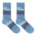 A pair of crew socks with a detailed watercolor-style print of a lake or river scene, featuring blue and light teal water, white ripples, and green reeds, displayed against a solid white background.