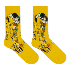 A pair of bright yellow crew socks featuring a printed art design inspired by Gustav Klimt's 'The Kiss', shown against a plain white background.