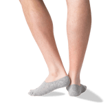 A close-up of a person's lower legs and feet wearing light gray low-cut no-show socks against a plain white background.
