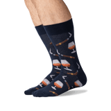 Navy socks with wine glass and bottle pattern worn by a person on a white background