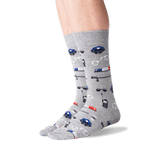A pair of crew socks worn on a person's feet, featuring a gray heather base with a repeating pattern of blue and red police cars, sirens, and badges.