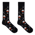 A pair of black crew socks with a repeating pattern of cognac whiskey glasses, cigars, and smoking pipes, displayed flat against a solid white background.