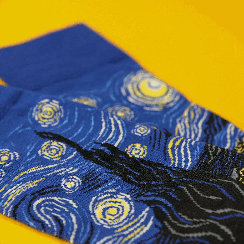 Blue socks with starry night design on a yellow background
