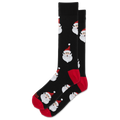 A pair of black crew socks featuring a repeating pattern of Santa Claus faces, with red heels, soles, and toes.