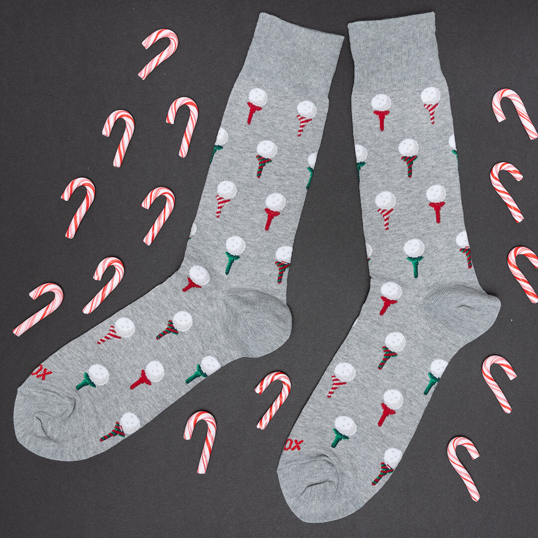 Gray socks with candy cane and golf ball patterns on a black background