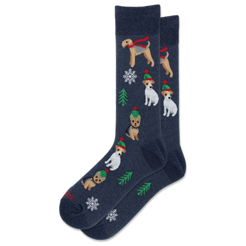 A pair of navy blue crew socks featuring a festive Christmas pattern with wirehaired dogs wearing red scarves and green hats, decorated with white snowflakes and green pine trees.