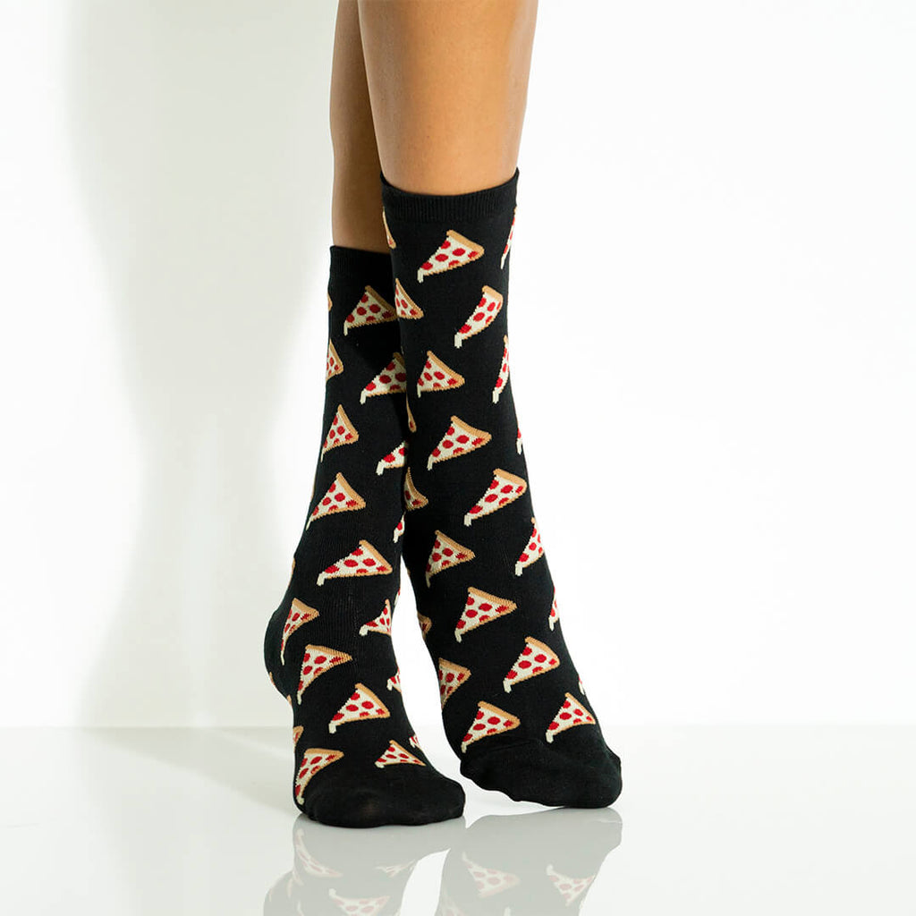 Black socks with pizza pattern worn by a woman on a white background