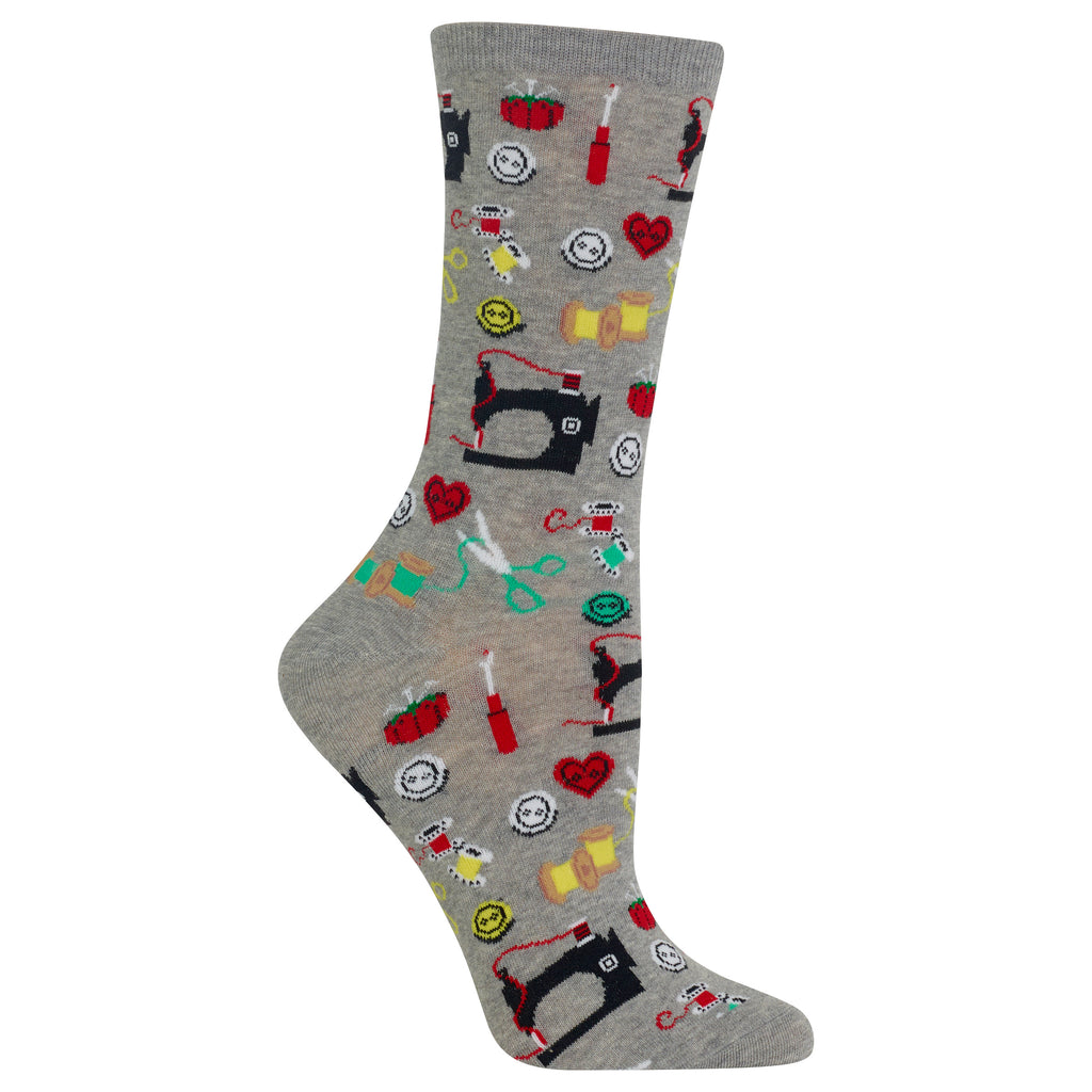 A single gray crew sock with a colorful pattern of sewing-themed icons including black sewing machines, red hearts, green scissors, yellow spools, and red thread spools, shown on a plain white background.