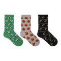 Three pairs of crew socks displayed side by side on a plain white background. The left pair is green with black and white soccer ball patterns, the middle pair is gray with orange basketball patterns, and the right pair is black with brown football patterns and thin green stripes.