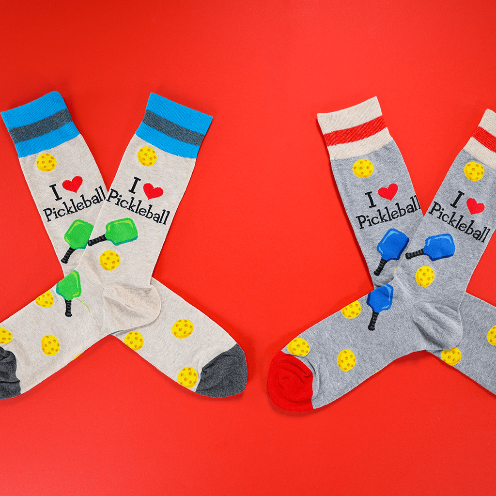 Two pairs of pickleball-themed socks on a red background