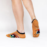 Person wearing orange socks with colorful designs on a white background