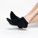 Black socks worn by a person on a white background thumbnail