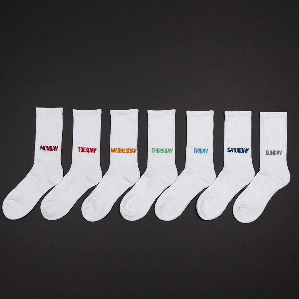 Set of white socks with days of the week text on a black background