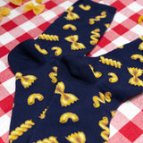 Navy blue socks with yellow pasta pattern on a red and white checkered tablecloth thumbnail