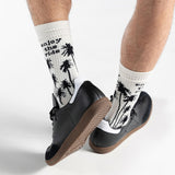 White socks with black palm tree design worn with black shoes on a white background thumbnail