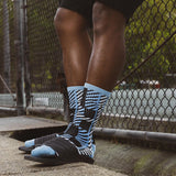 Person wearing black and blue patterned socks with a blurred background