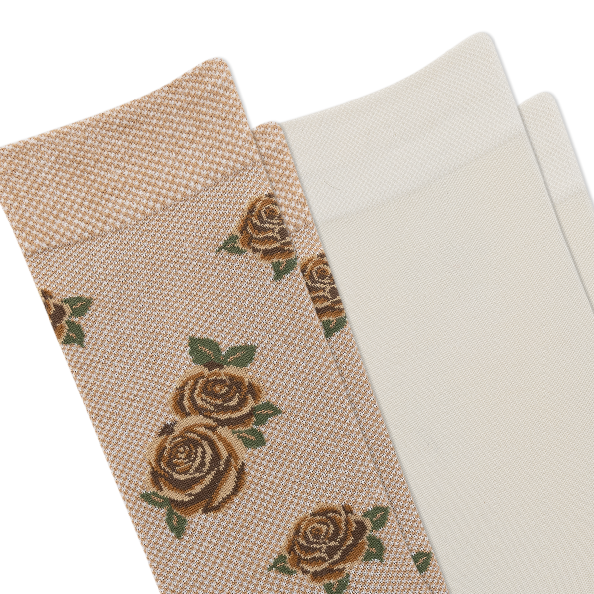 A close-up of a beige sock with a woven rose pattern, brown toe and heel, and another pair of light cream socks.