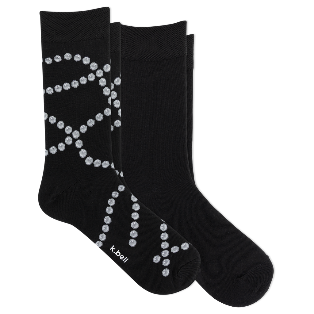 Two black crew socks with a white dotted pearl pattern, displayed on a clean white background. The brand name 'k-bell' is printed in white near the toe of the front sock.