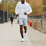Man running on a sidewalk wearing a white outfit thumbnail