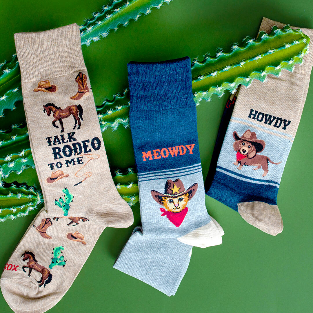 Assorted men's western-themed novelty HOTSOX crew socks with horses, cowboy hats, cats and dogs.