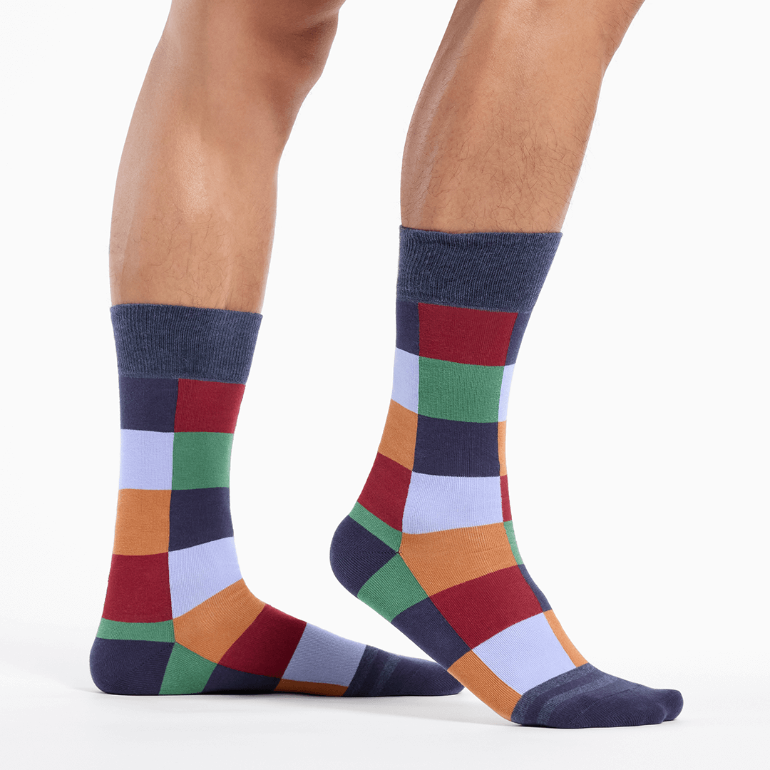 Colorful checkered socks worn by a person on a white background