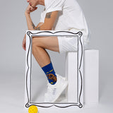 Person wearing blue socks with 'The Dinker' design and white sneakers on a light gray background thumbnail