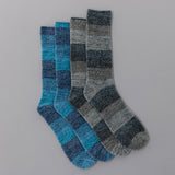 Two pairs of checkered socks in blue and gray on a gray background