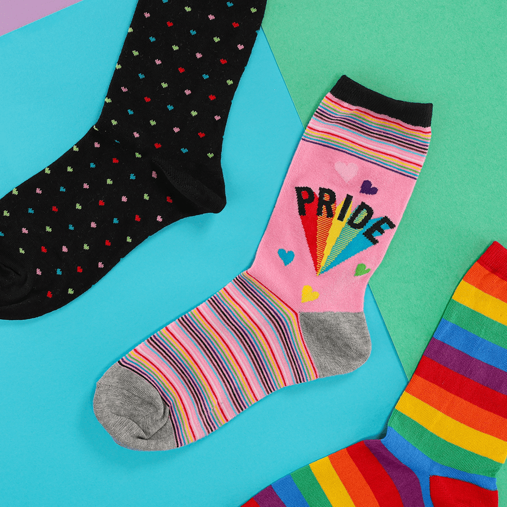 Colorful socks with rainbow patterns and 'PRIDE' text on a multicolored background