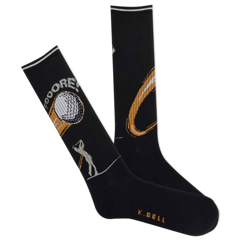 A pair of K.Bell men's active golf crew socks in black with a gold and green design, featuring a golf ball and tees and the phrase 'Fooore!"