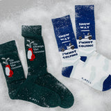 Set of four pairs of socks with winter-themed designs on a snowy background