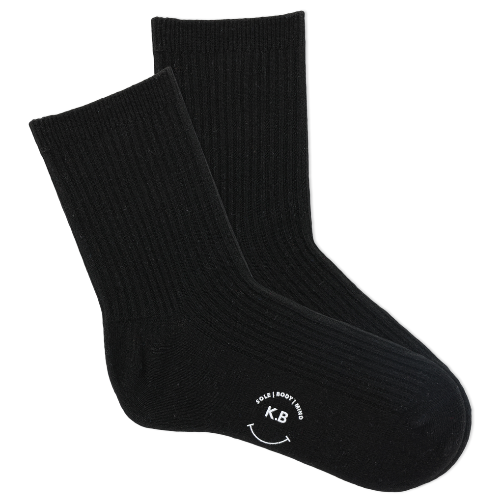 Pair of black socks with a smiley face and initials on a white background