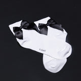 White socks with black bows on a black background, featuring the brand 'k.bell'. thumbnail