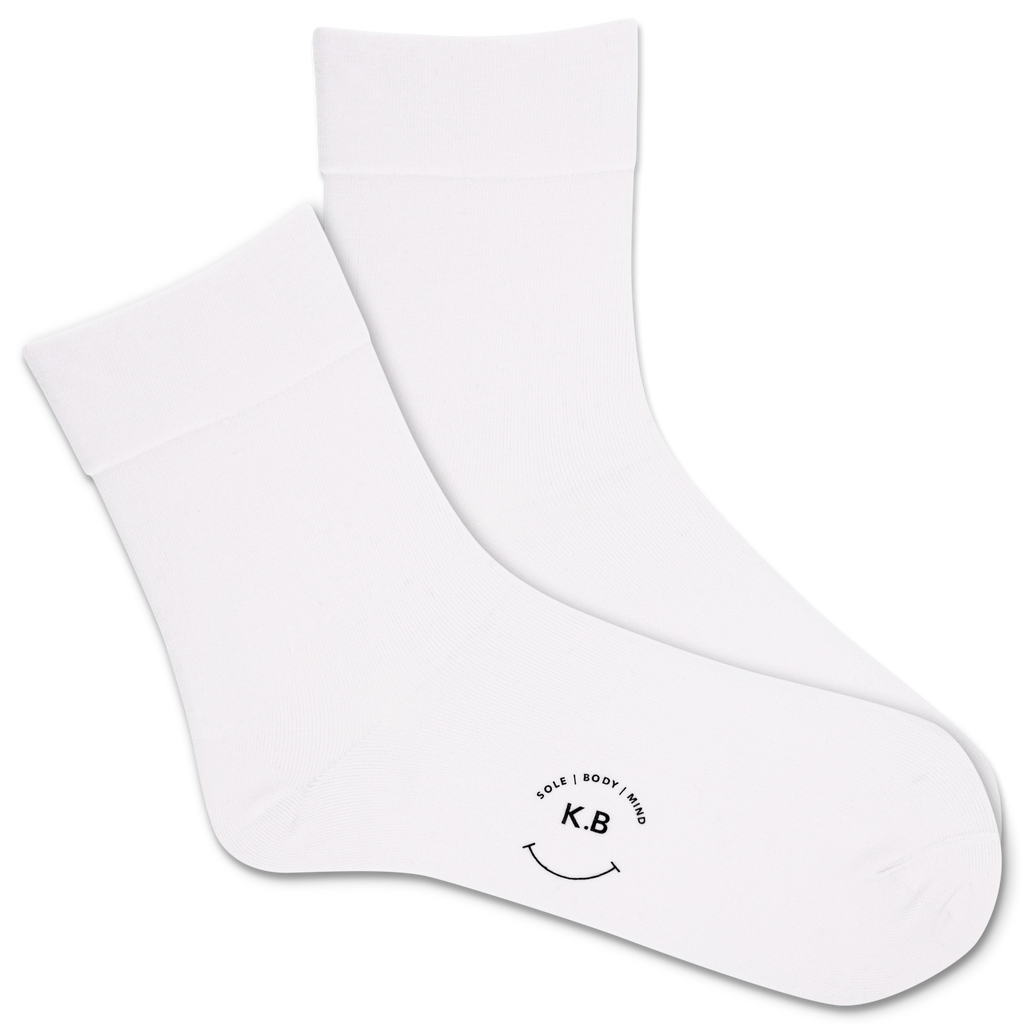 White socks with a smiley face and 'K.B' logo on a white background