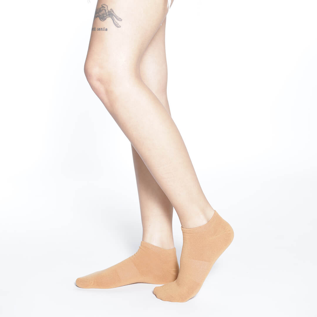 Beige socks worn by a person on a white background