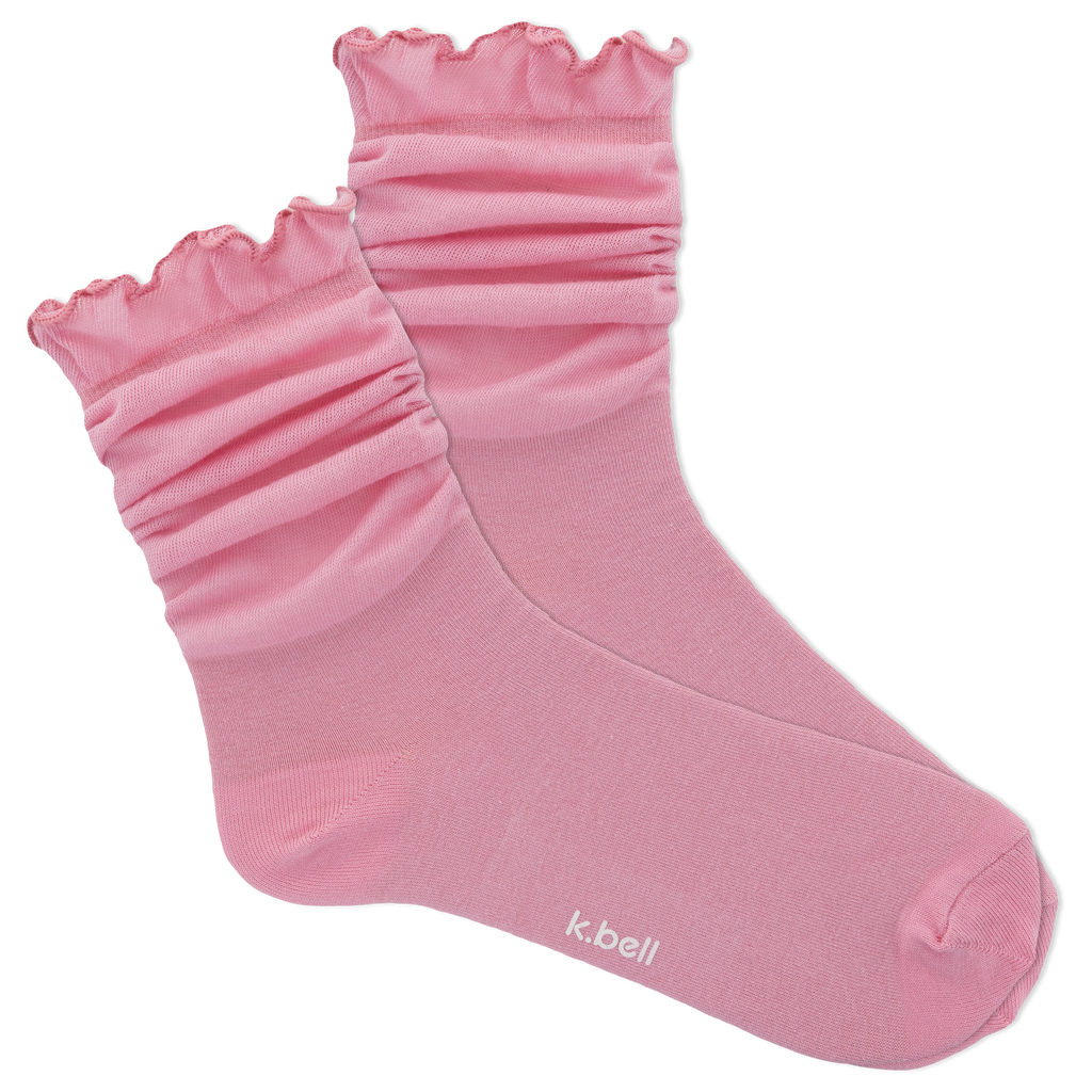 Pink socks with ruffled top on a white background, featuring the brand 'k.bell'.