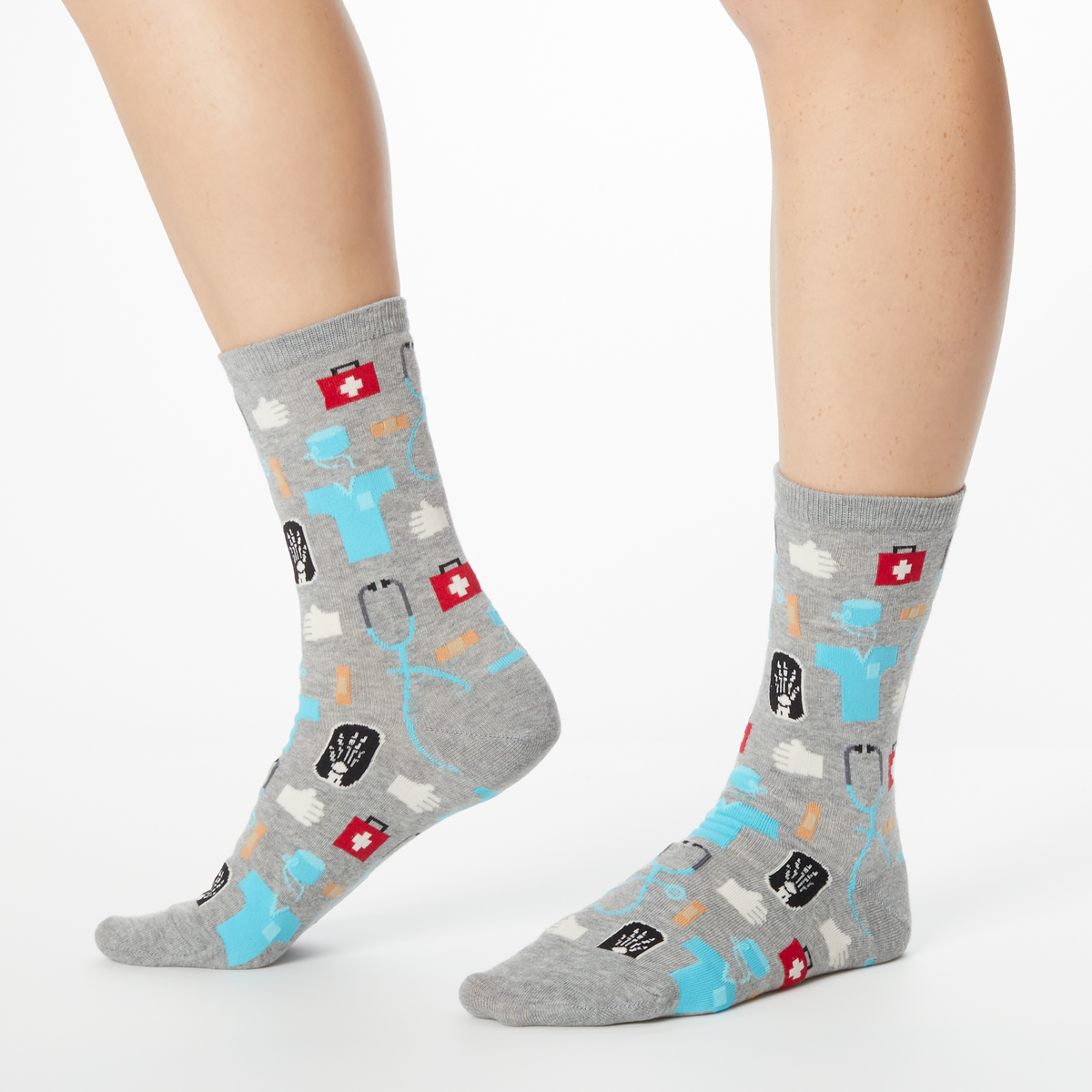 A pair of women's crew socks with a medical supplies print including images of a stethoscope, pills, and a hospital badge.